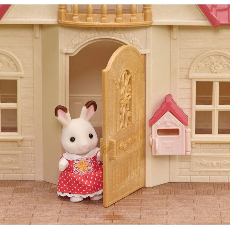 Calico Critters dollhouse with red roof and rabbit figure in red polka dot dress