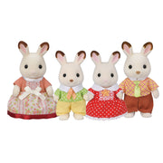 Four Sylvanian Families chocolate rabbit figurines in colorful traditional outfits on white background