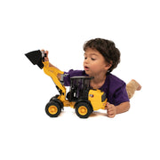 Child playing with yellow CAT wheel loader toy truck by Bruder