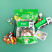 Garbage themed play dough kit with trucks, recycling toys and brown dough on green background