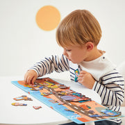 Child playing with Magneti'Stories Building Site magnetic puzzle showing construction workers and vehicles