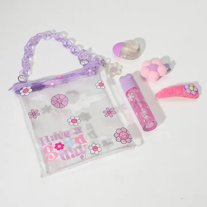 Clear tote bag with purple handles and flower prints containing beauty accessories