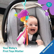 Baby in car seat playing with colorful bird toy with ribbons and hanging attachment