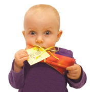 Baby holding and chewing on colorful crinkly Baby Paper toy with yellow ribbon