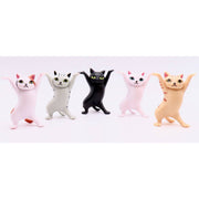 Five colorful dancing cat figurines with raised arms on white background