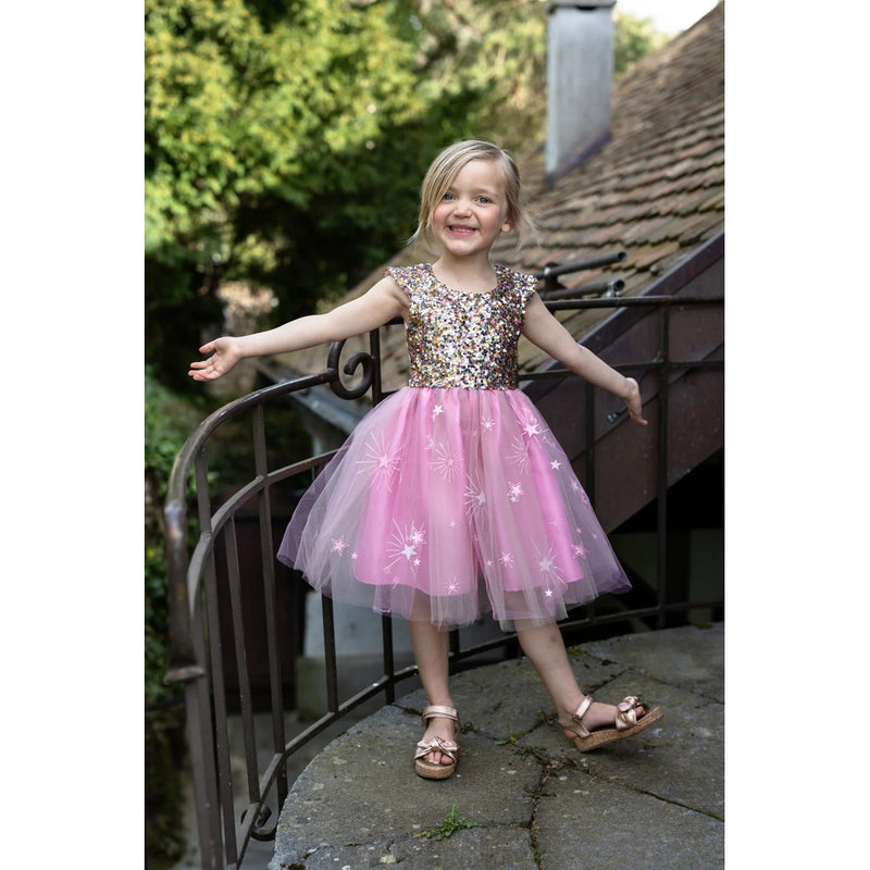 Young girl wearing sparkly sequined bodice dress with pink tulle skirt decorated with stars