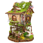 Detailed fairytale tree house miniature model with moss roof, butterflies, and white rabbit