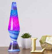 Blue and pink lava lamp with bubbling liquid displayed on desk with plant and decor