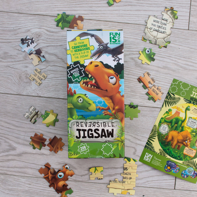 Dinosaur reversible jigsaw puzzle with scattered pieces showing carnivore to herbivore theme
