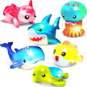Six colorful light-up bath toys including shark, whale, jellyfish, pufferfish, unicorn, and turtle on white background