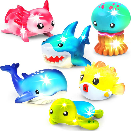 Six colorful light-up bath toys including shark, whale, jellyfish, pufferfish, unicorn, and turtle on white background