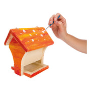 Hand painting white polka dots on orange wooden bird feeder craft kit