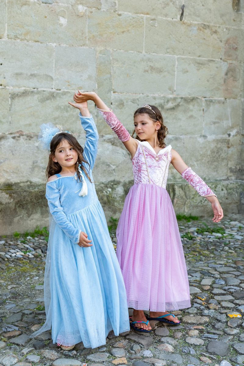 Two girls in princess costumes, one blue dress one pink dress, posing together outdoors