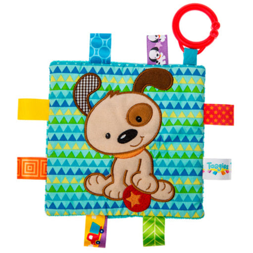 Taggies crinkle toy with puppy design on teal patterned fabric with colorful ribbon tags.