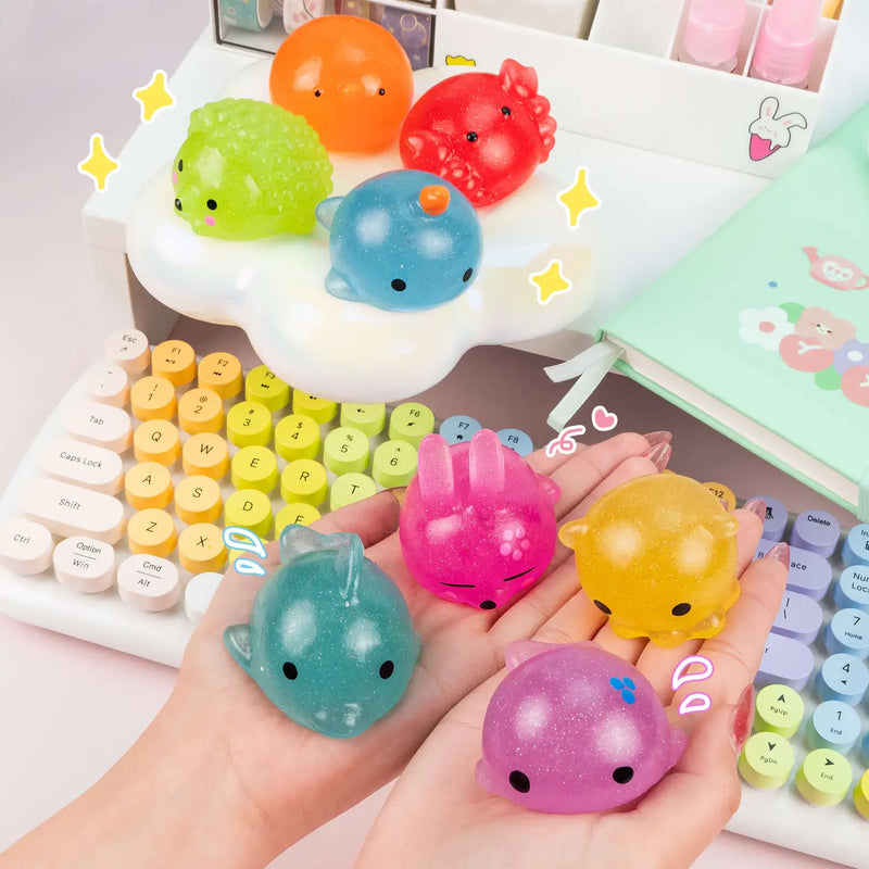 Colorful glittery mochi squishy toys held in hands on kawaii desk setup
