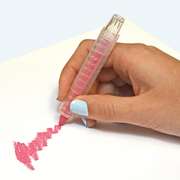 Hand holding pink Wonder Stix crayon drawing on white paper