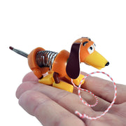 Miniature Slinky Dog toy held in hand showing orange body with spring mechanism