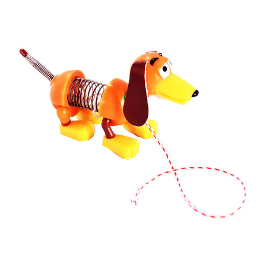Orange miniature Slinky Dog toy with yellow feet and spring body on white background