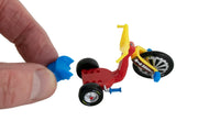 Hand holding miniature Big Wheel tricycle toy showing scale and detail