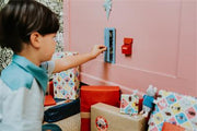 Child playing with Little Mouse Door furniture kit including red accessories in dollhouse setting