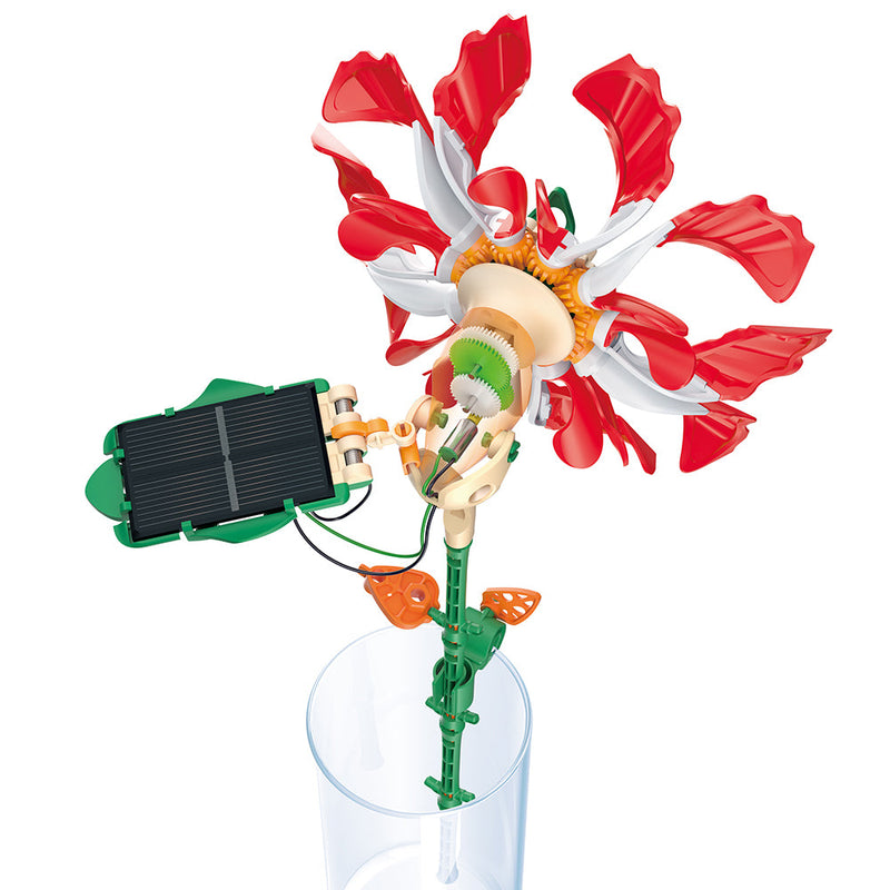 Solar-powered robotic flower with red and white petals in clear vase