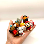 Collection of small cartoon dog figurines held in open palm