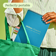 Blue Lifelines FlowArt notebook being placed in green tote bag by person in striped shirt
