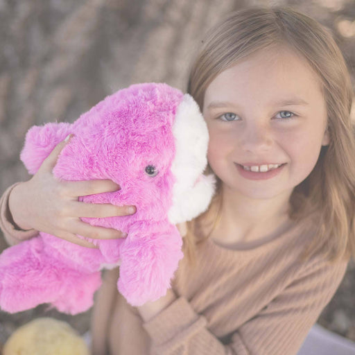 Young girl holding pink plush shark toy with white ears