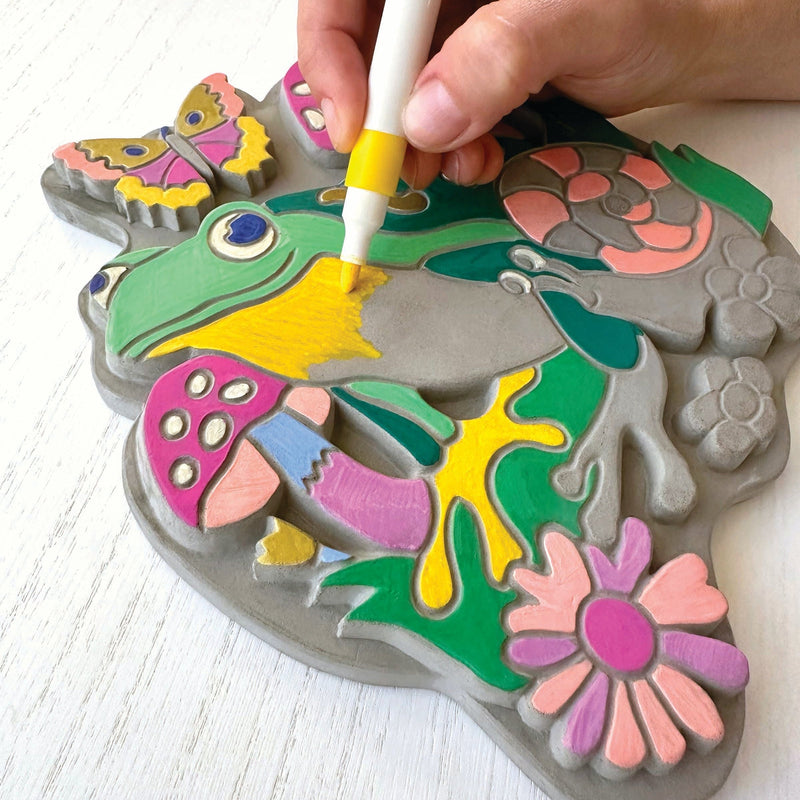 Hand using marker to color garden stone with butterfly and flower designs