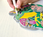 Hand painting colorful garden stone craft with marker showing detailed design