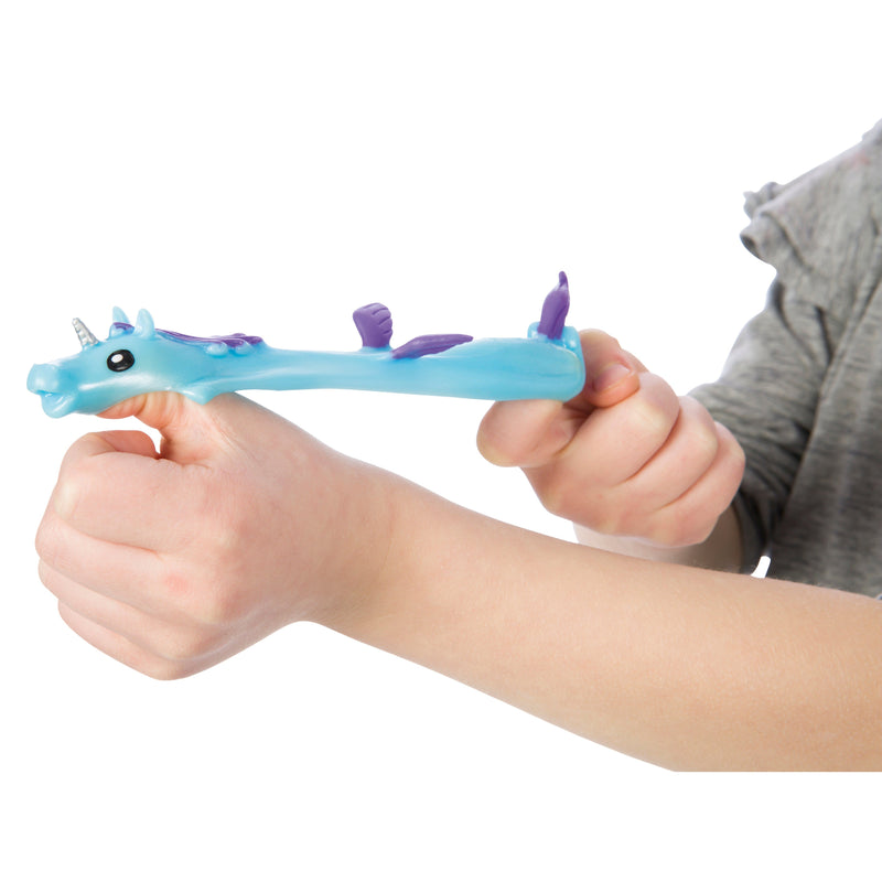 Child's hands holding blue unicorn flinger toy with purple mane and horn