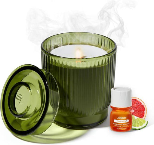 Green ribbed glass candle with lid and essential oil bottle on white background