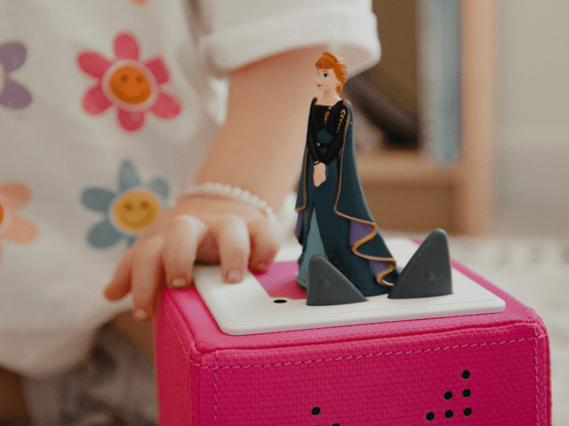 Child playing with Tonie Disney Frozen 2 Anna figure on pink Toniebox speaker