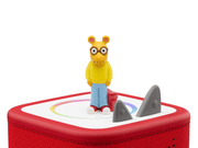 Arthur Tonie figure with glasses and yellow sweater on red Toniebox with shark fins