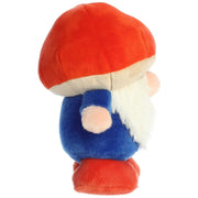 Side view of plush toy gnome with a red mushroom cap, blue body and red shoes on a white background