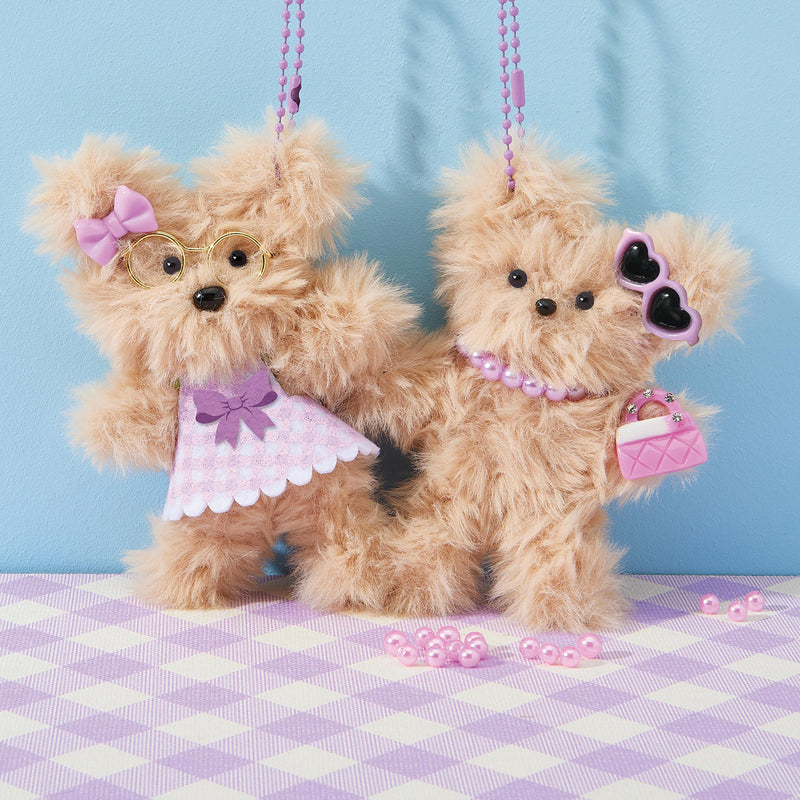 Two adorable chenille teddy bears with pink accessories and pearl necklaces on striped surface