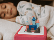 Disney castle Tonie audio figure on Toniebox with child sleeping in background