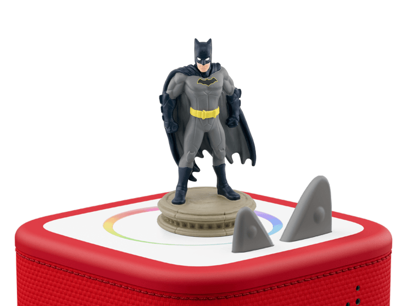 Batman Tonie figure standing on red Toniebox speaker with gray accessories