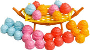 A set of colorful, poop-shaped toy toys arranged on and around a small yellow and orange basket-like stand against a plain white background.