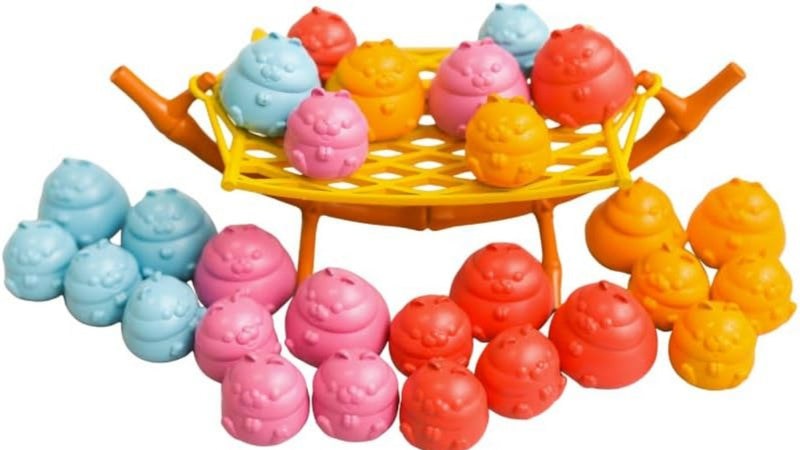 A set of colorful, poop-shaped toy toys arranged on and around a small yellow and orange basket-like stand against a plain white background.