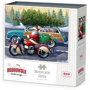 Boxed jigsaw puzzle titled "Motorcycle Santa" by Andy C. Ellis, showing a vintage illustration of Santa riding a motorcycle with a Christmas tree on a teal wood-paneled car.