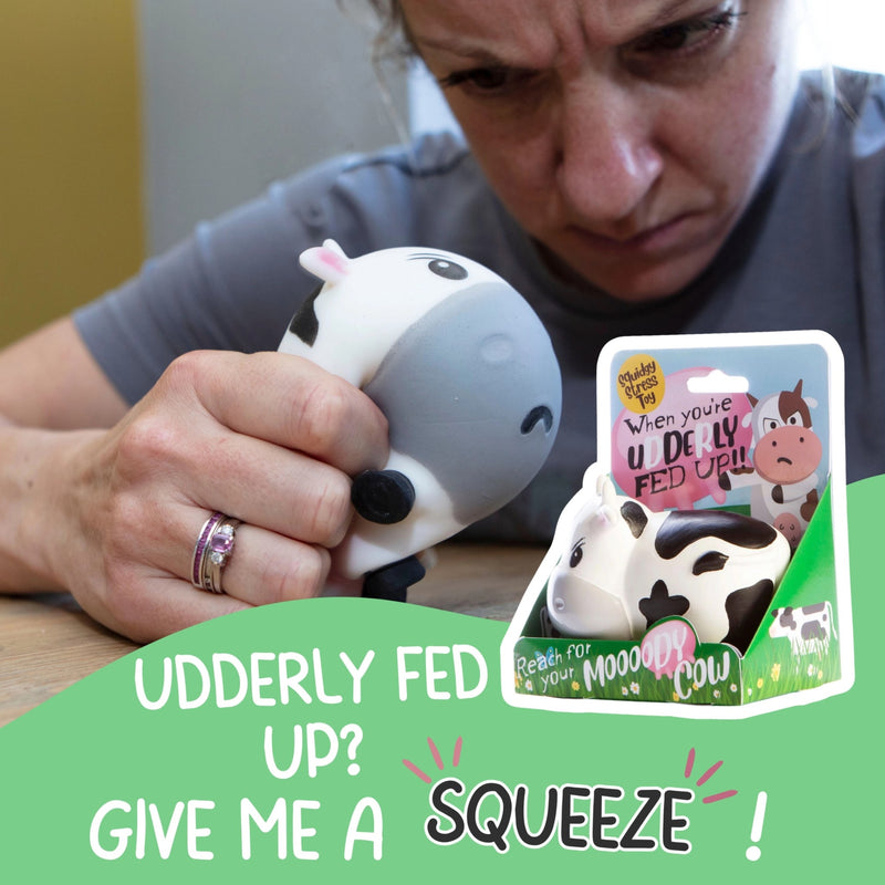 Person holding a cow-shaped stress reliever toy with text and inset image of cow toy.