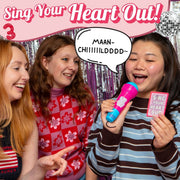Three friends singing with a microphone and 'Sing Your Heart Out!' sign in a festive setting.