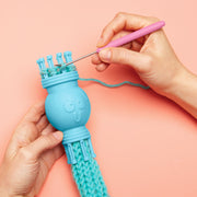 Hands using Bright Stripes knitter to make a colorful yarn tube