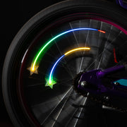 Two Star Brightz color-morphing spoke lights glowing on a moving bicycle wheel.