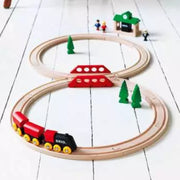 Classic figure 8 wooden train set with a red engine and track on a white wooden surface.