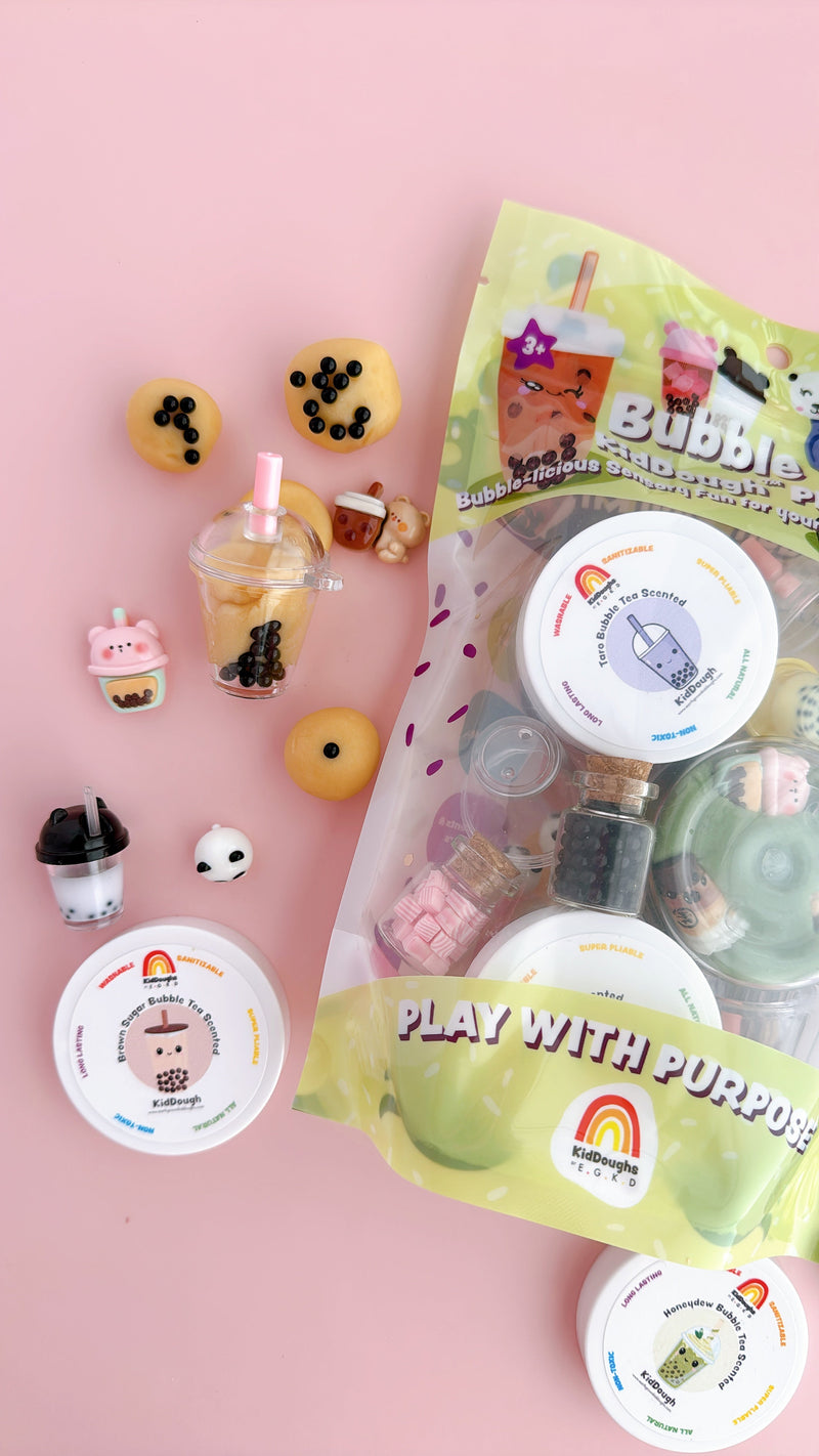 Bubble tea themed play dough kit with miniature cups and boba pearls on pink background