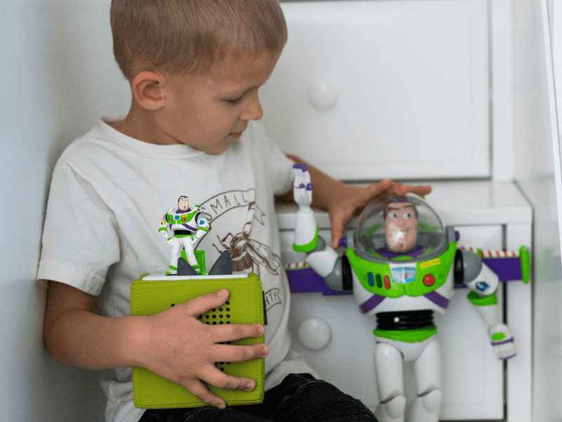 Child playing with Buzz Lightyear Tonie figure and green Toniebox audio system