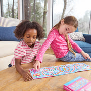 Two children playing Rainbow Race magnetic board game on wooden table.