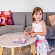 Young girl using Tiger Tribe Mini Transfer Magic Flower Fairies activity set at coffee table